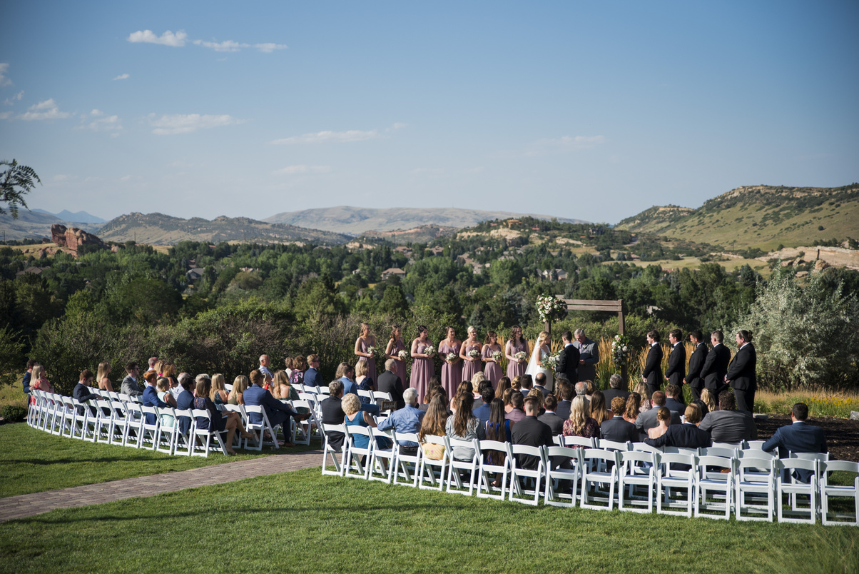 A wedding ceremony with mountains in the background at The Manor House in Littleton, Colorado.